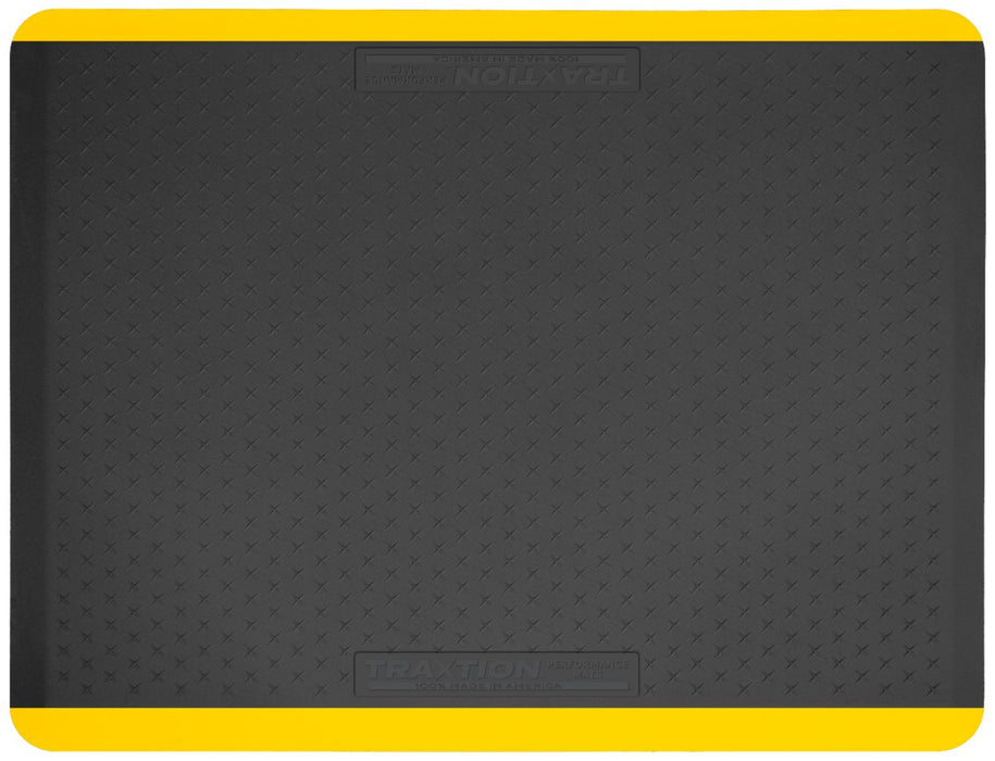 Above view of the top of a black Traxtion mat with yellow safety strips.